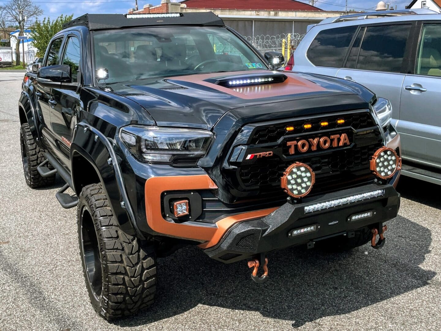 A black and orange toyota truck parked in the parking lot.